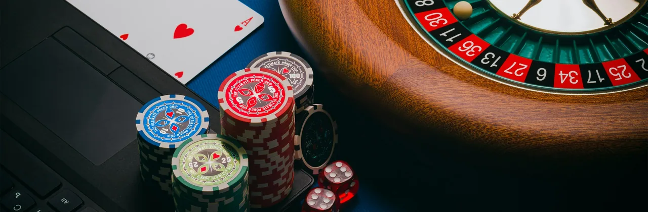 Roue de roulette, jetons, cartes et d&eacute;s sur un tapis vert fonc&eacute;