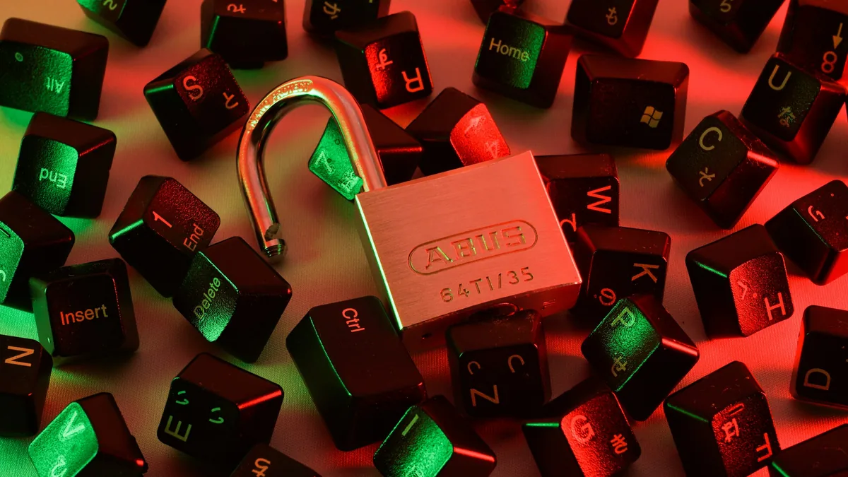 An open padlock among scattered keyboard keys